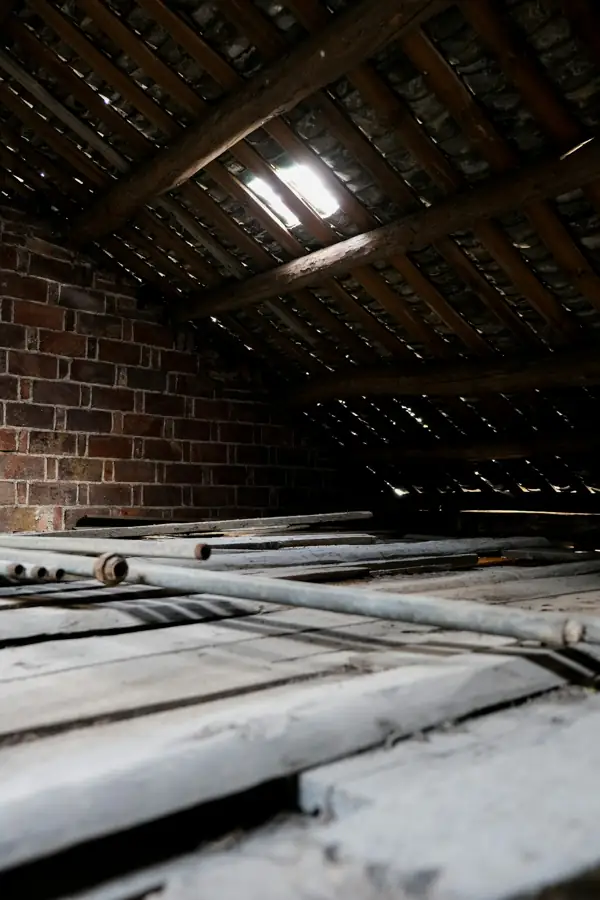 Old attic with brick walls and leftover materials before insulation work