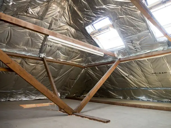 Attic under renovation with foil-faced insulation and roof windows