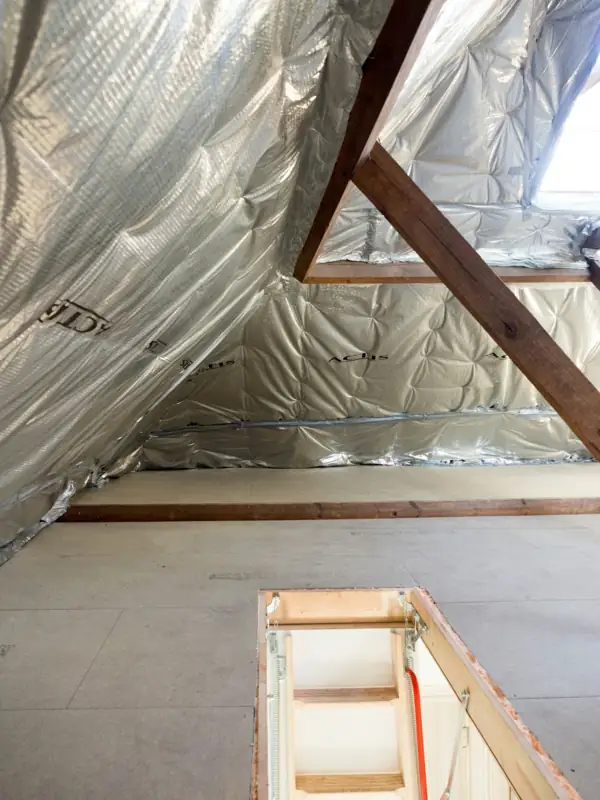 Attic room with reflective insulation sheets and new flooring