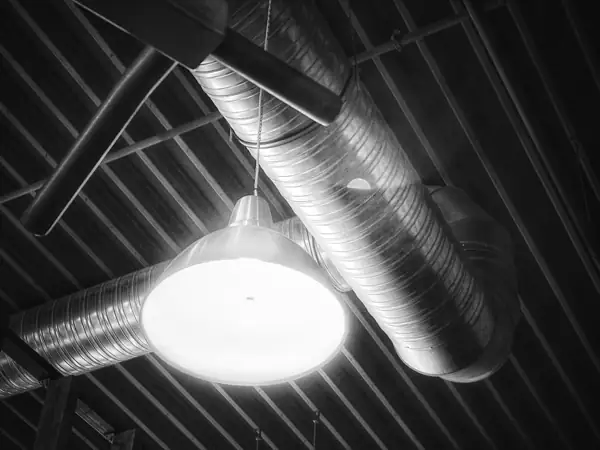Spiral metal ducts running along an exposed ceiling