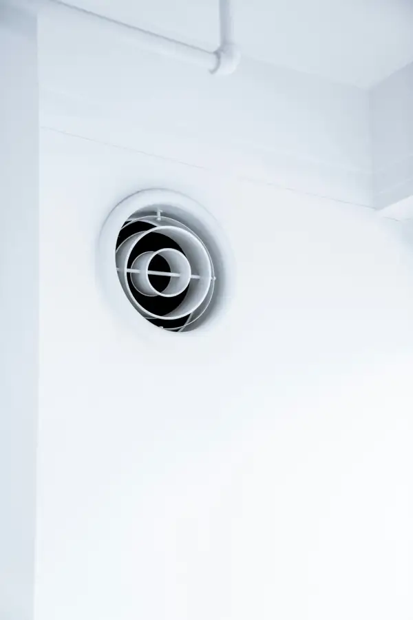 Round air outlet in a white wall
