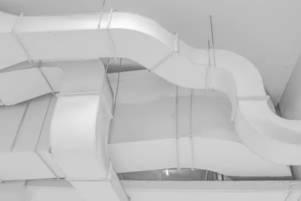 White fabric-wrapped ducts weaving across a ceiling