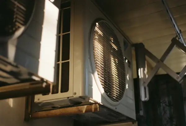 Outdoor condenser unit mounted under a building overhang