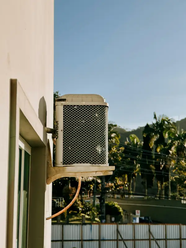 Wall-mounted outdoor AC condenser on a bracket
