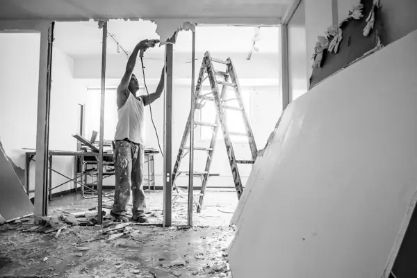 Contractor working on a ladder in a room under renovation