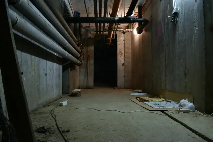 Unfinished concrete basement with exposed pipes overhead