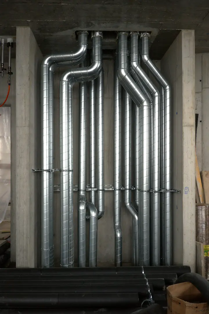 Rows of new galvanized metal ducts installed along a wall