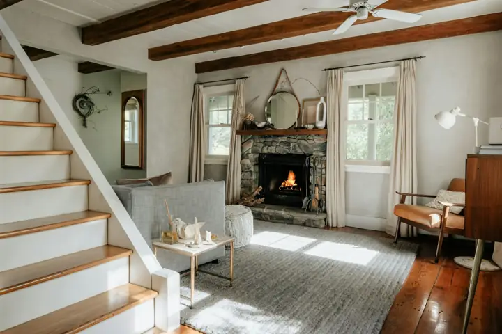 Bright living room with a fireplace and staircase in an older home